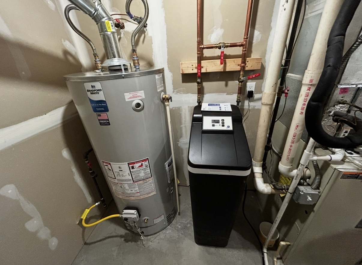 Finished water softener installation next to a Bradford White water heater