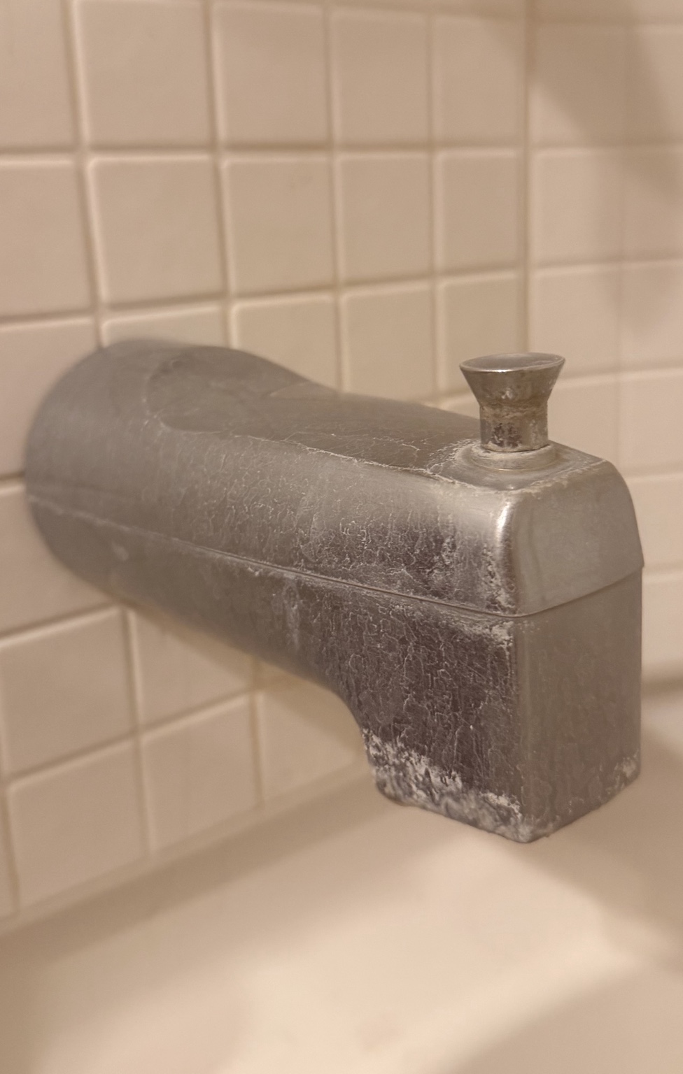Mineral buildup visible on a tub spout in a Direct Plumbing Solutions field photo