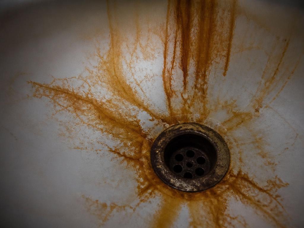 Orange iron staining in a white sink basin